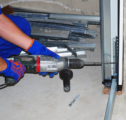 Technician Working on Garage with Drill for a Garage Door Tune-Up in Rockwall, TX 