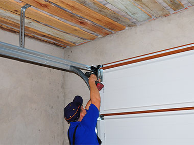 man in blue in the middle of a Garage Door Repair in Rowlett