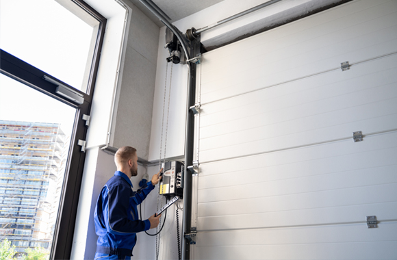 A Service Technician inspecting a Garage Door after a Garage Door Track Repair in Fort Worth, TX